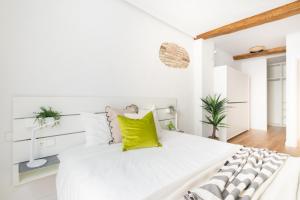 - une chambre blanche avec un grand lit et des oreillers jaunes dans l'établissement Increíble, amplio, cómodo y céntrico apartamento, à Pampelune