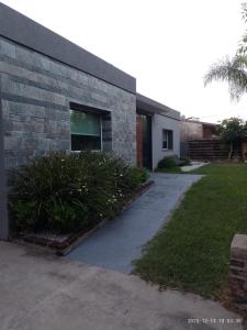a brick building with a sidewalk next to a yard at Casa en Ybarlucea para familia hasta 7 personas in Ybarlucea