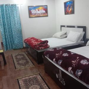 a room with two beds and a ottoman in it at Somnath residency radhe nikunj in Vrindāvan