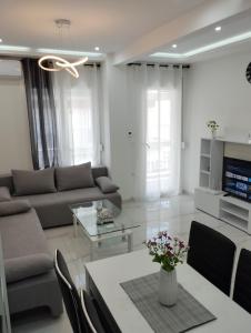 een woonkamer met een bank en een tafel bij Λαμπερό Διαμέρισμα 1 in Thessaloniki