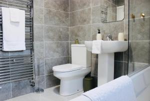 a bathroom with a toilet and a sink at Chic & Cushy 3 Bed House, short and long term in Birmingham