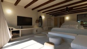 a living room with a couch and a television at ARC suites in Ios Chora