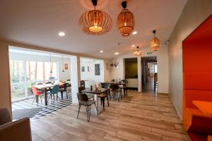 Un restaurante con mesas, sillas y luces. en ibis Haguenau Strasbourg Nord, en Haguenau