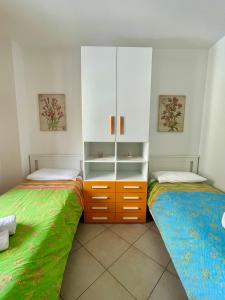 um quarto com 2 camas individuais e um armário em Sea la Vie em Alghero