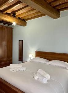 a bedroom with a white bed with towels on it at Sibolla Holidays in Altopascio