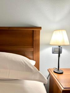 アルトパーショにあるSibolla Holidaysのベッド横の机にランプが備わります。