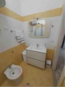 a bathroom with a toilet and a sink and a mirror at Sabina's House in Acciaroli