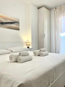 a white bedroom with two beds and a window at Sea la Vie in Alghero