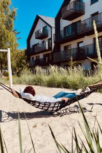 a person laying in a hammock on the beach at 500m Sea, Terrace - Sunny Calm Coastal Retreat in Dźwirzyno