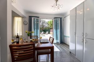 comedor con mesa de madera y sillas en Villa Kataleya en Svoronata