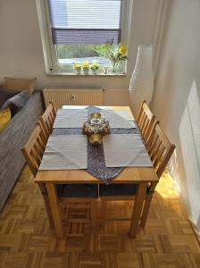 uma mesa de jantar com 2 cadeiras e uma janela em Apartment nah am Strand in BreitungenWerra em Herrenbreitungen