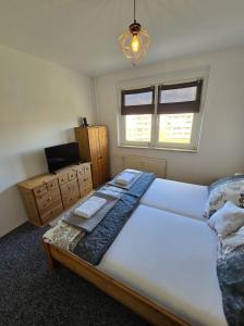um quarto com uma grande cama branca e uma janela em Apartment nah am Strand in BreitungenWerra em Herrenbreitungen