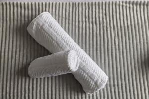 2 asciugamani bianchi arrotolati su un letto di The Kilnwood House a Crawley
