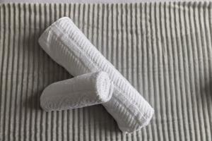 two white rolled up towels on a bed at The Kilnwood House in Crawley