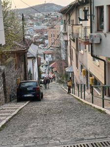 un coche aparcado al lado de una calle adoquinada en Himber Rooms, en Sarajevo