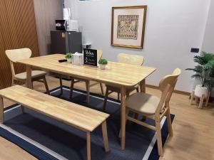 a wooden table and chairs with a table and a bench at Ratchadadome hostel in Bangkok