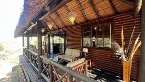 um alpendre de uma cabina com uma cadeira e janelas em Kruger Kumba - Lahlekile Nathi em Marloth Park
