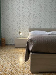a bedroom with a bed and a patterned wall at Luna Apartment in Civitavecchia