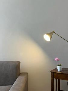 ein Wohnzimmer mit einem Sofa, einer Lampe und einem Tisch in der Unterkunft Luna Apartment in Civitavecchia