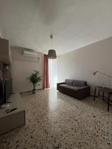 uma sala de estar com um sofá e uma mesa em Luna Apartment em Civitavecchia