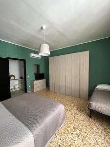 um quarto com 2 camas e uma parede verde em Luna Apartment em Civitavecchia