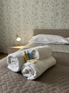 einen Stapel Handtücher auf dem Bett in der Unterkunft Luna Apartment in Civitavecchia