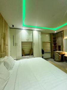 a bedroom with a large bed with a green light at Luxurious 3Bedroom Apartment with Personal Chef in Maroko