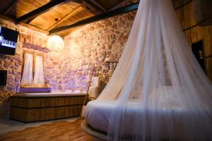 a bed with a mosquito net in a room with a tub at La Nuit d'Amélie in Norma