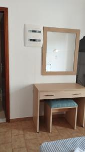a dressing table with a mirror on a wall at Maria Apartments in Pefki