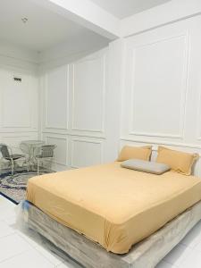 a large bed in a white room with a table at Minamo Homestay Modern Tengah Kota Payakumbuh in Payakumbuh