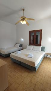 1 dormitorio con 2 camas y ventilador de techo en Maria Apartments, en Pefki