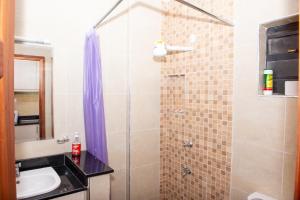 La salle de bains est pourvue d'une douche et d'un lavabo. dans l'établissement WEST SUITE NEWLY FURNISHED APARTMENT, à Nairobi