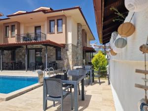 a patio with tables and chairs next to a house at @Home Dalyan in Dalyan