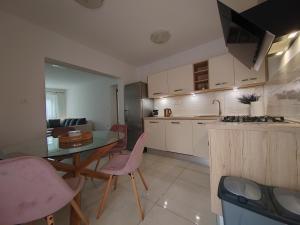 a kitchen and dining room with a table and chairs at Apartments and pool Luminous in Pula