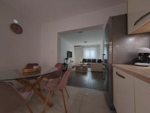 a kitchen and living room with a table and chairs at Apartments and pool Luminous in Pula +45 photos