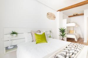 - une chambre blanche avec un grand lit et des oreillers jaunes dans l'établissement Increíble, amplio, cómodo y céntrico apartamento, à Pampelune