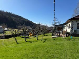 un champ verdoyant avec des arbres devant une maison dans l'établissement Cazare Colibita Casa Lipan, à Colibiţa