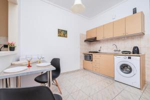 a kitchen with a washing machine and a table with chairs at City Life Marina apartment No. 5 in Ampavris
