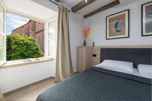 a bedroom with a bed and a window at Sounds of Ragusa in Dubrovnik