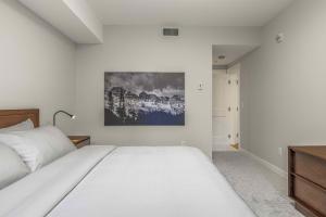 a bedroom with a bed and a painting on the wall at Brand New - TimberLodge Spacious 2br in Canmore