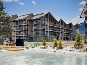 a large building with a rink in front of it at Brand New - TimberLodge Spacious 2br in Canmore