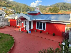 uma casa vermelha com uma entrada vermelha em QUEENS COTTAGE - individual cottage em Ooty