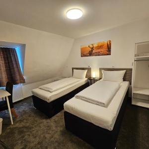 um quarto de hotel com duas camas e uma mesa em Hotel Kölner Hof em Mülheim an der Ruhr