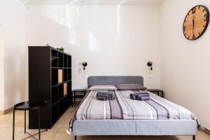 een slaapkamer met een bed en een klok aan de muur bij La Piazzetta in Piacenza