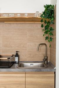 a stainless steel sink in a kitchen with wooden cabinets at La Piazzetta in Piacenza