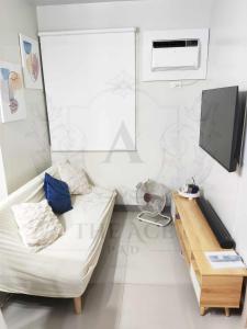 un soggiorno bianco con divano e TV di THE ACE PAD at SMDC Charm Residences a Manila