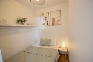 a small bedroom with a bed and a lamp at Express Premium apartments - city center in Tartu