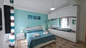 een blauwe slaapkamer met een bed en een spiegel bij Sky Apartment by Casa in mente in Cefalù