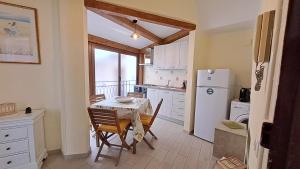 een keuken met een tafel en een witte koelkast bij Sky Apartment by Casa in mente in Cefalù