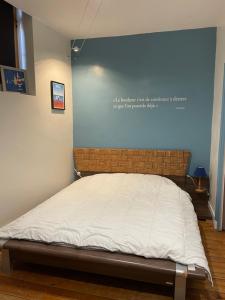 Bett in einem Zimmer mit blauer Wand in der Unterkunft proche plage in Les Sables-dʼOlonne
